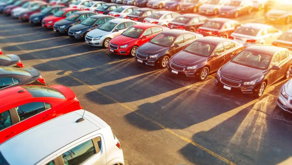 New cars sitting on an auto dealership lot.