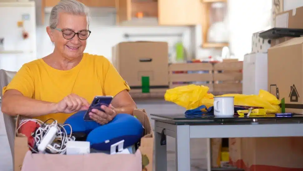 A woman has a box of items and is doing some home decluttering