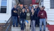 Greenhouse Project volunteers on the steps of the renovated and cleaned-up 912House.