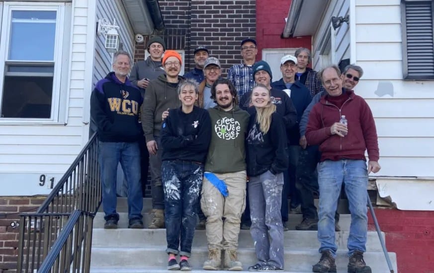 Greenhouse Project volunteers on the steps of the renovated and cleaned-up 912House.