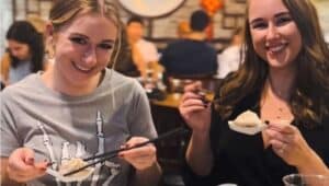 Two young women enjoying dumplings at Tom's Dim Sum in Media.