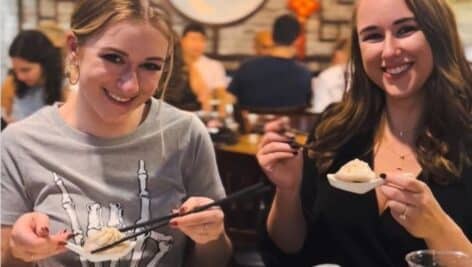 Two young women enjoying dumplings at Tom's Dim Sum in Media.