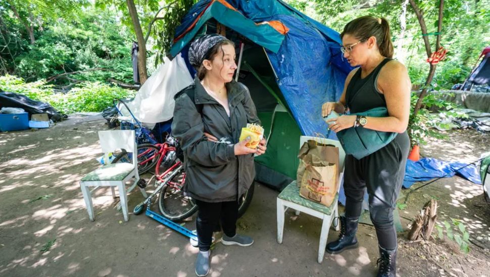 Draya LaMacchia (left) speaks with homeless advocate Sephanie Sena at a homeless encampment in Norristown.