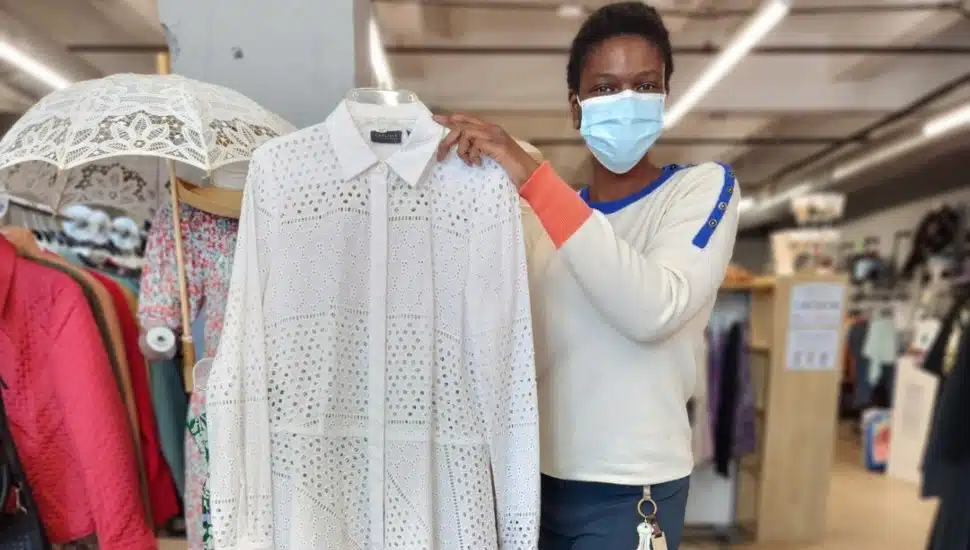 A woman holding up a dress in The Wardrobe store.