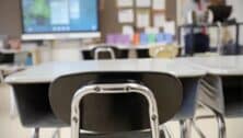An empty school desk in a classroom.