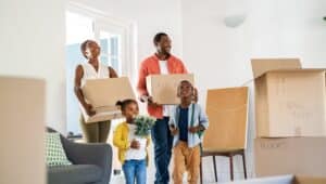 A Black American family moves into a new home surrounded by boxes.