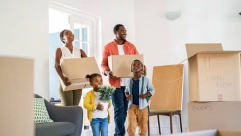 A Black American family moves into a new home surrounded by boxes.