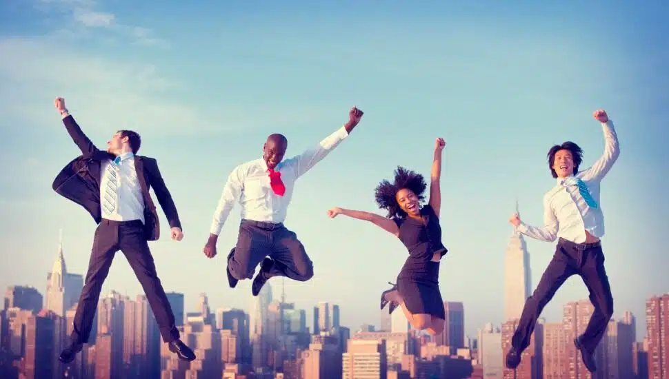 Businesspeople joyously jumping up together.