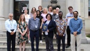 Delaware County Controller Joanne Phillips and her staff outside the Delaware County Courthouse. Phillips is holding the Certificate of Achievement for Excellence in Financial Reporting.