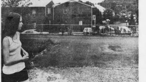 In a 1975 Inquirer photo, Zoe Harrington looks over the area on Lawrence Road in Broomall where her sister Gretchen Harrington was last seen.