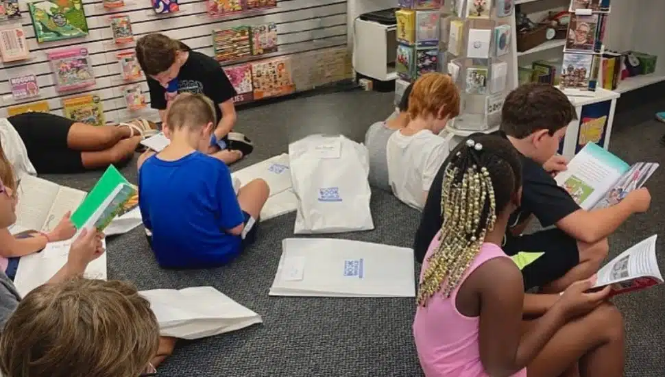 Children reading books on the floor of Children's Book World in Haverford