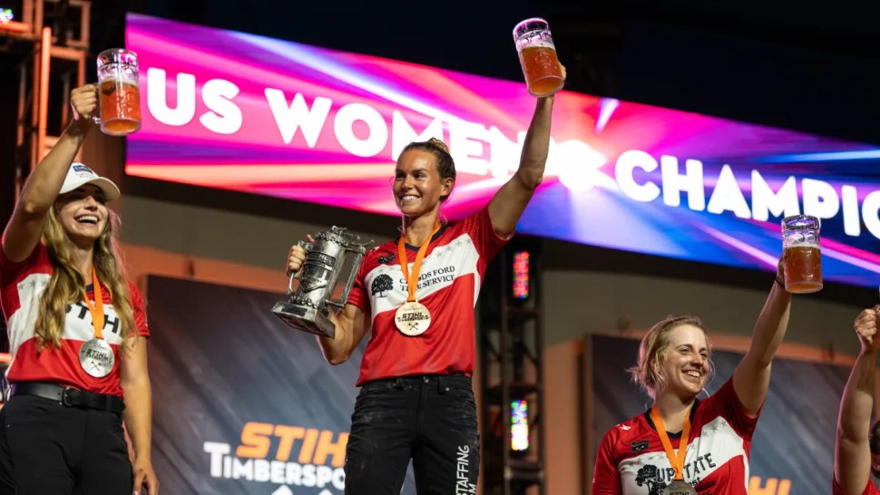 Martha King of Chadds Ford is shown holding her trophy and toasting her victory after winning the National Womens Championship at the Stihl Timbersports competition.