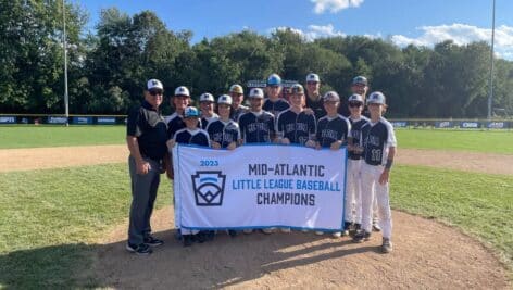 The Media Little League team displays a sign proclaiming their regional championship win.