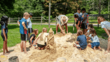 Chuck Feld teaches kids at Hands on History Camp how to make a professional sand castle.