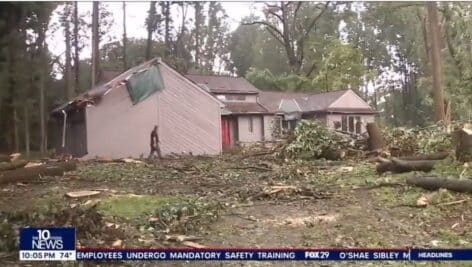 A storm-ravaged home in Chadds Ford with trees down and roof damage.