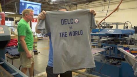 Holding up a "Delco vs. the World" T-shirt made by B&E Sportswear in Broomall in honor of the Media Little League placing in the Little League World series.