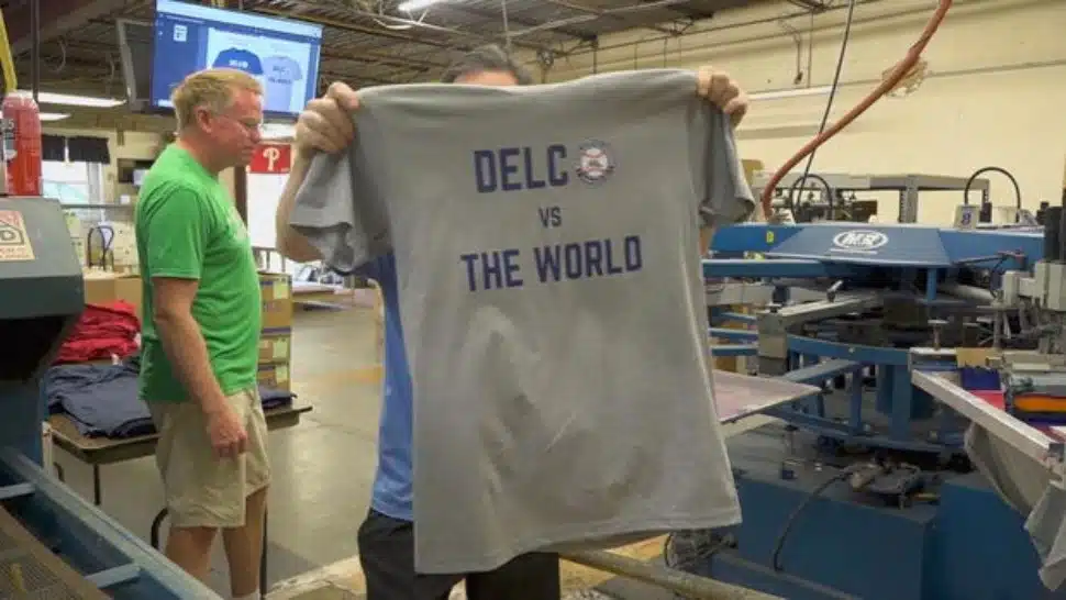 Holding up a "Delco vs. the World" T-shirt made by B&E Sportswear in Broomall in honor of the Media Little League placing in the Little League World series.