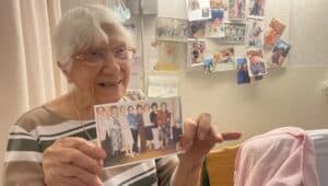 Minnie Pieatso, 100, shows a photo of herself with her nine lifelong girlfriends.