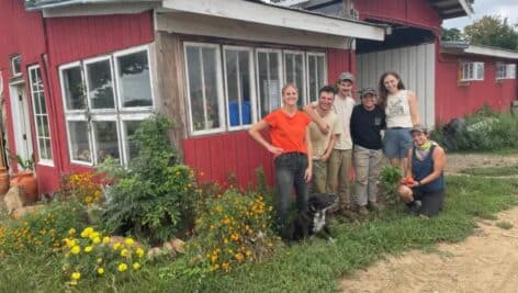 Employees of the Urban Roots Farm in front of its red barn.
