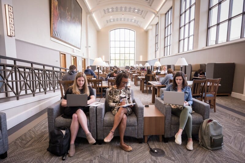 College students do some studying and work in a university hall.