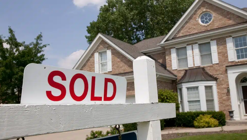 A nice-looking suburban home with a sold sign out front.