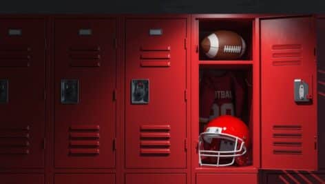 A football locker room with a football helmet and a football in a locker.