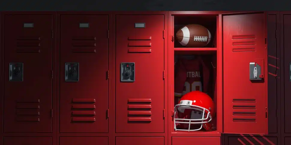 A football locker room with a football helmet and a football in a locker.