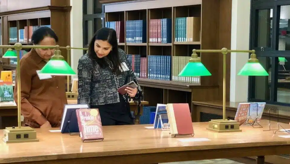 Two Penn State faculty check out selected books on display at the University's library on the University Park campus.