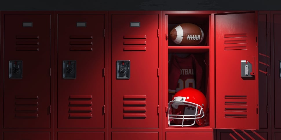 American football locker room with equipment, ball and helmet.