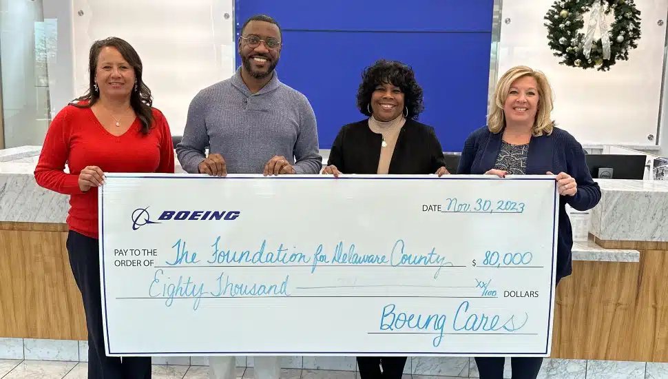 Representatives of Boeing Philadelphia and the HOPE program hold a large replica of Boeing's ,000 grant check.