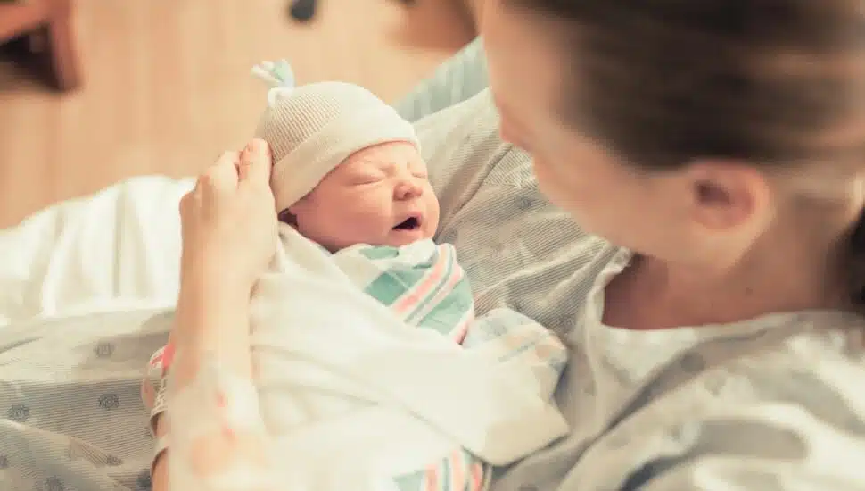 A mother with a new-born baby wrapped in a blanket