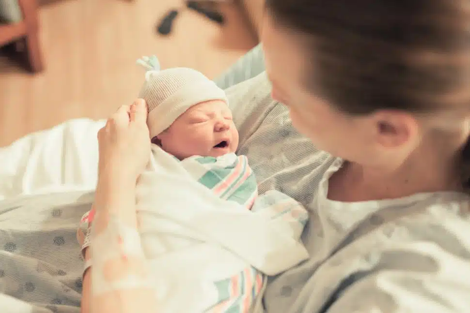 A mother with a new-born baby wrapped in a blanket