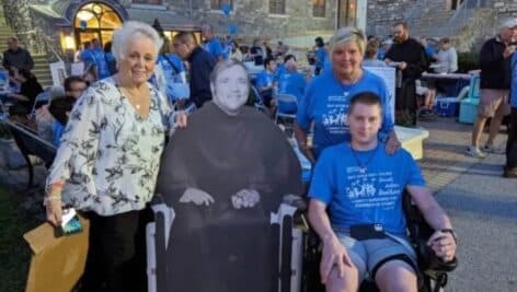 At a pilgrimage in honor of Bill Atkinson held in September, are, from left, Mary Moody with a cardboard cutout of Atkinson and Marie Keith with her son Cole.