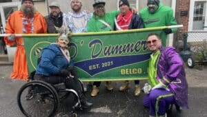The core founders of the D’Dummers Day Parade and festivities, holding the banner from left, John Fralinger, PJ Dolan, Will McCollaum, Joe Taulman, Ron Fisher and Jamie Pagliei. Out front are D’Dummers supporters Samantha Twining and Matt “Matty Ice” McGinley.
