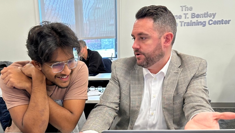 student smiling with instructor engaged in conversation