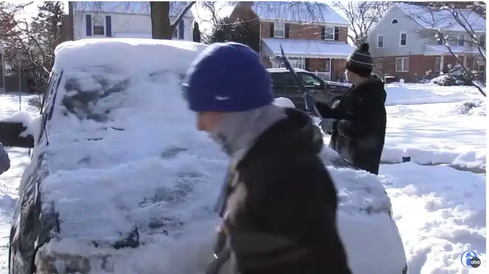 Members of the Springfield High School lacrosse team help a neighbor dig out from the snow.
