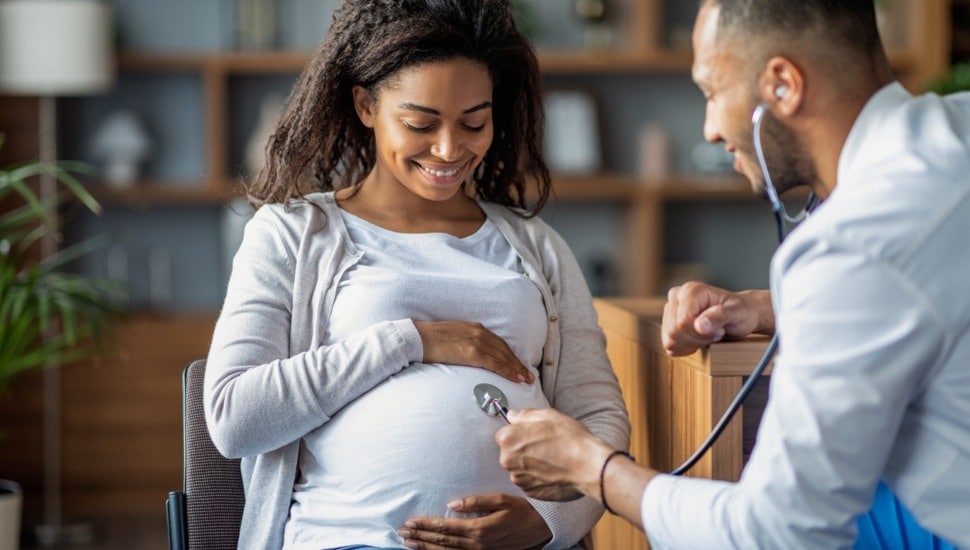 A pregnant woman is examined by a physician.