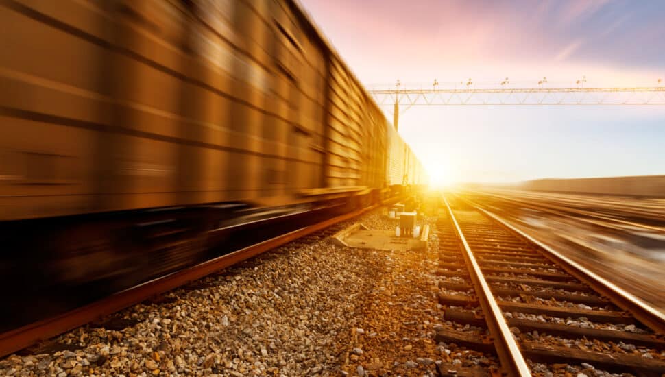 A fast-moving freight train at sunset.