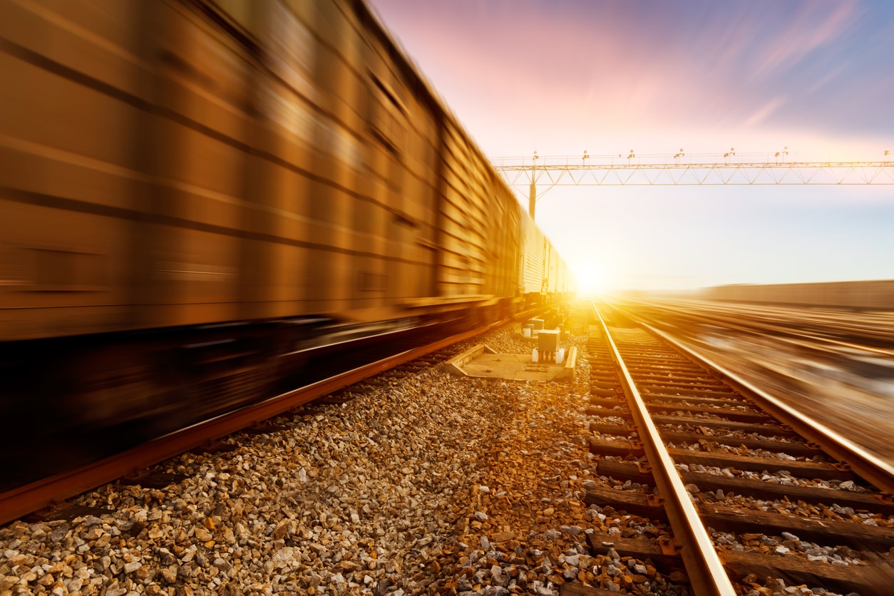 A fast-moving freight train at sunset.