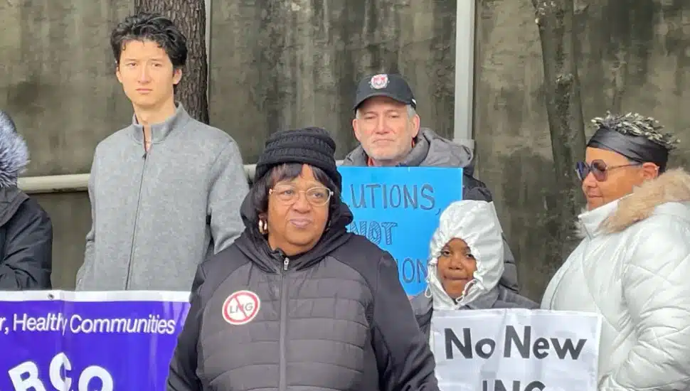 Neumann University political science professor Dr. Robert McMonagle at a protest with a sign and behind and to the right of Zulene Mayfield, chairperson of Chester Residents Concerned for Quality Living.