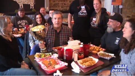 The owners and staff at Wilson's Secret Sauce in Upper Darby gather around some of their best barbecue entrees.