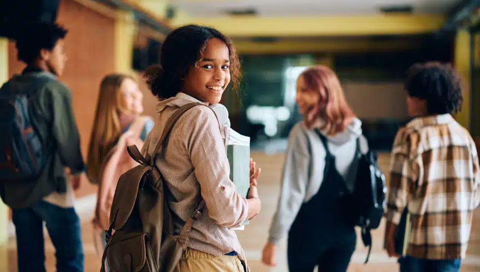 High school students walking in a school hallway.