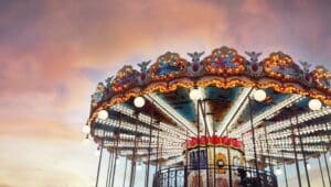 Part of popular vintage, retro carousel (merry-go-round) by the Eiffel Tower in Paris on sky sunset background. France.
