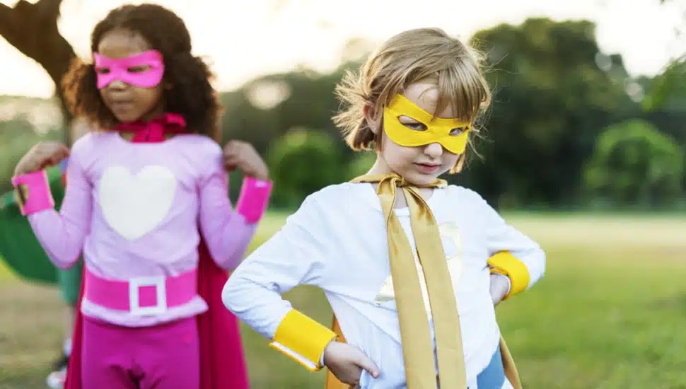 Two young children in super hero costumes