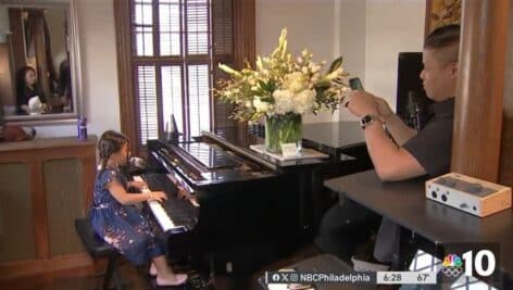 Zoe Erianna, 7, plays a tune on the piano. A bouquet of flowers sent by Beyonce sit on top of the piano.