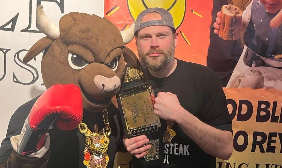 The new Cheesesteak Bowl professional eater champion Dan Kennedy with a mascot at Marple Public House in Broomall.