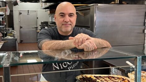 Owner Marco Morabito standing behind Nico's Pizza's counter.