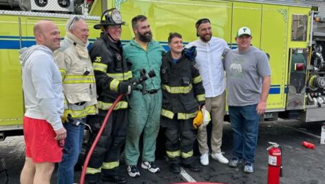 Jason and Travis Kelce pose with members of the Brookline Fire Company in front of a fire truck in Havertown.