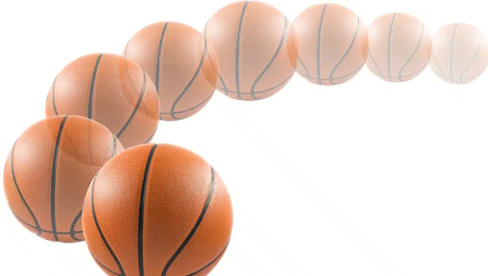 A time-lapse image of a basketball curving to the right.