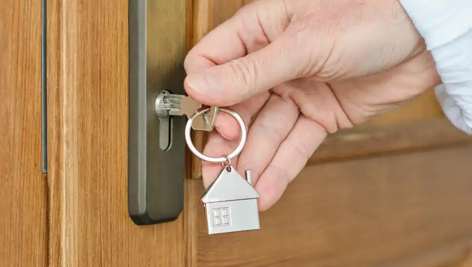 A guest with a house key opens a door at an Airbnb.
